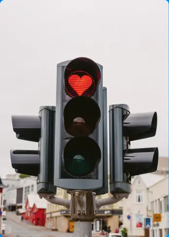Feu de signalisation en Islande avec un signal rouge en forme de cœur, ajoutant une note de charme à la rue de la ville.