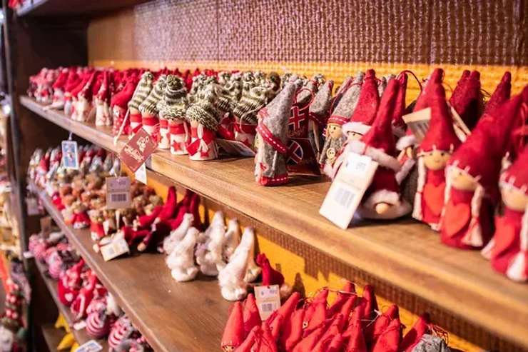 Une étagère dans une boutique islandaise présentant des figurines d'elfes rouges, ornements et souvenirs traditionnels de Noël.