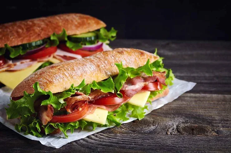 Des sandwichs frais garnis de légumes et de bacon, servis sur du pain croustillant.