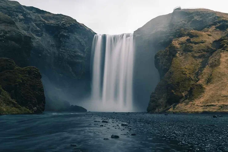 Puissante cascade Sk&oacute;gafoss tombant depuis les falaises en Islande, c&eacute;l&egrave;bre pour son arc-en-ciel.