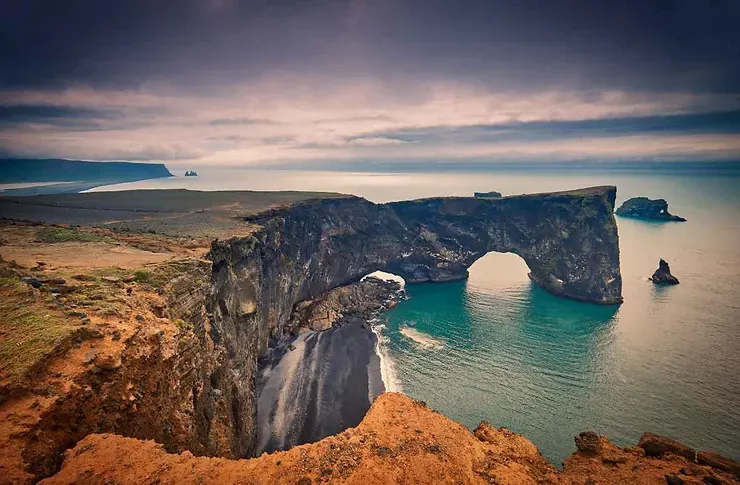 Vue panoramique sur l'arche naturelle de Dyrh&oacute;laey en Islande avec l'oc&eacute;an Atlantique.