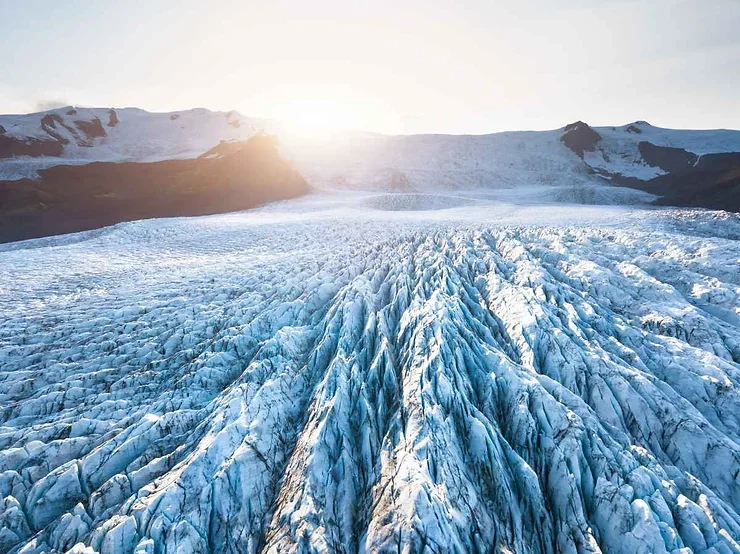 Immense glacier islandais captur&eacute; au lever du soleil, r&eacute;v&eacute;lant sa surface sculpt&eacute;e par le temps.