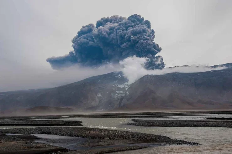 &Eacute;ruption spectaculaire d'un volcan islandais, projetant des nuages de cendres dans un d&eacute;cor sauvage et dramatique.