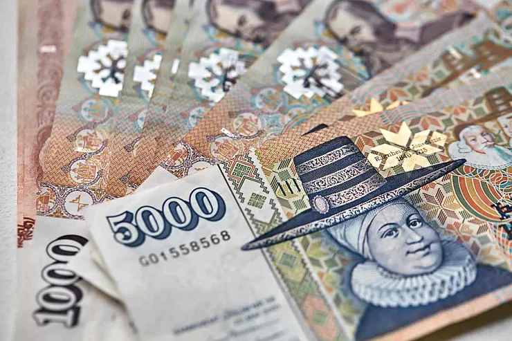  Des billets islandais de différentes valeurs disposés en éventail, mettant en avant des portraits historiques et des motifs décoratifs traditionnels.