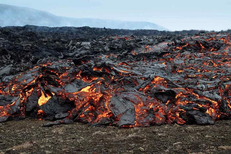 La lave incandescente se refroidit pour former une couche noire et brillante.