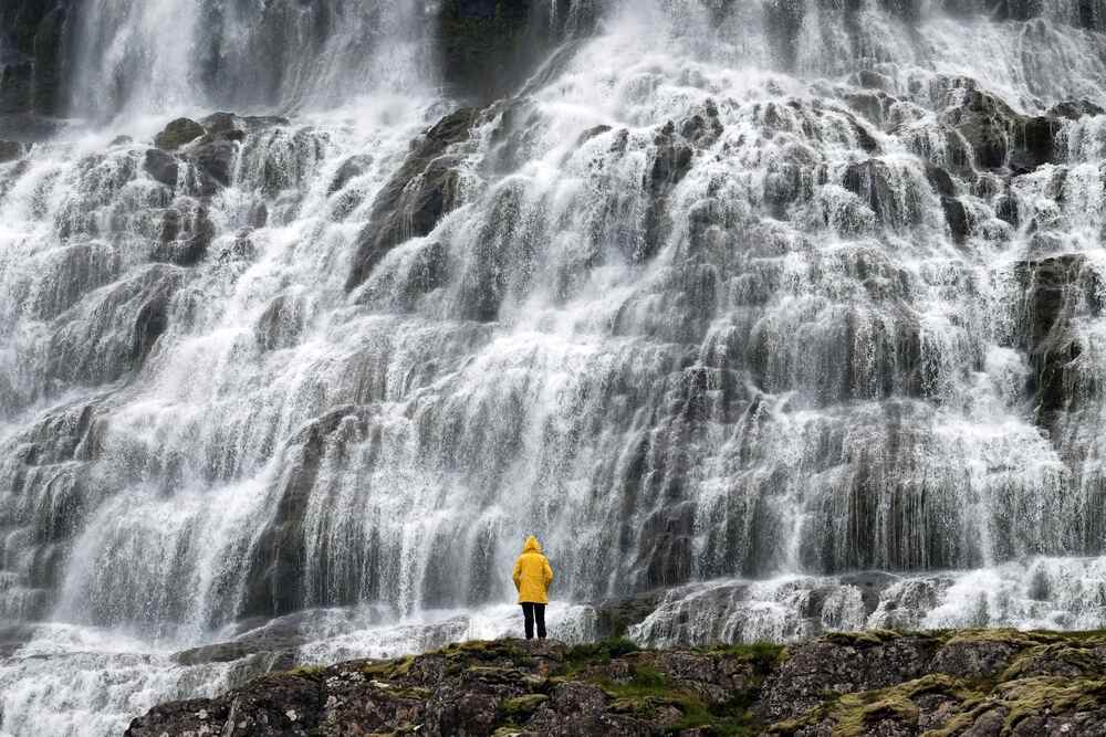 Cascade Dynjandi en cascade, s’élargissant gracieusement comme un voile de mariée dans les fjords islandais.