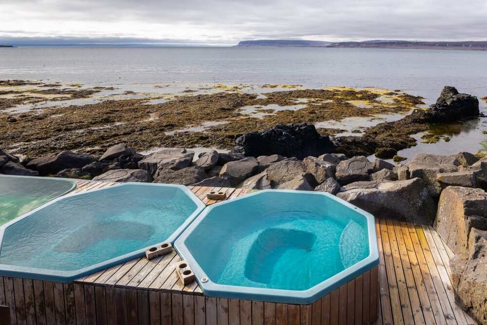 Trois bassins octogonaux remplis d'eau chaude avec vue sur l'océan Atlantique et un littoral rocheux.
