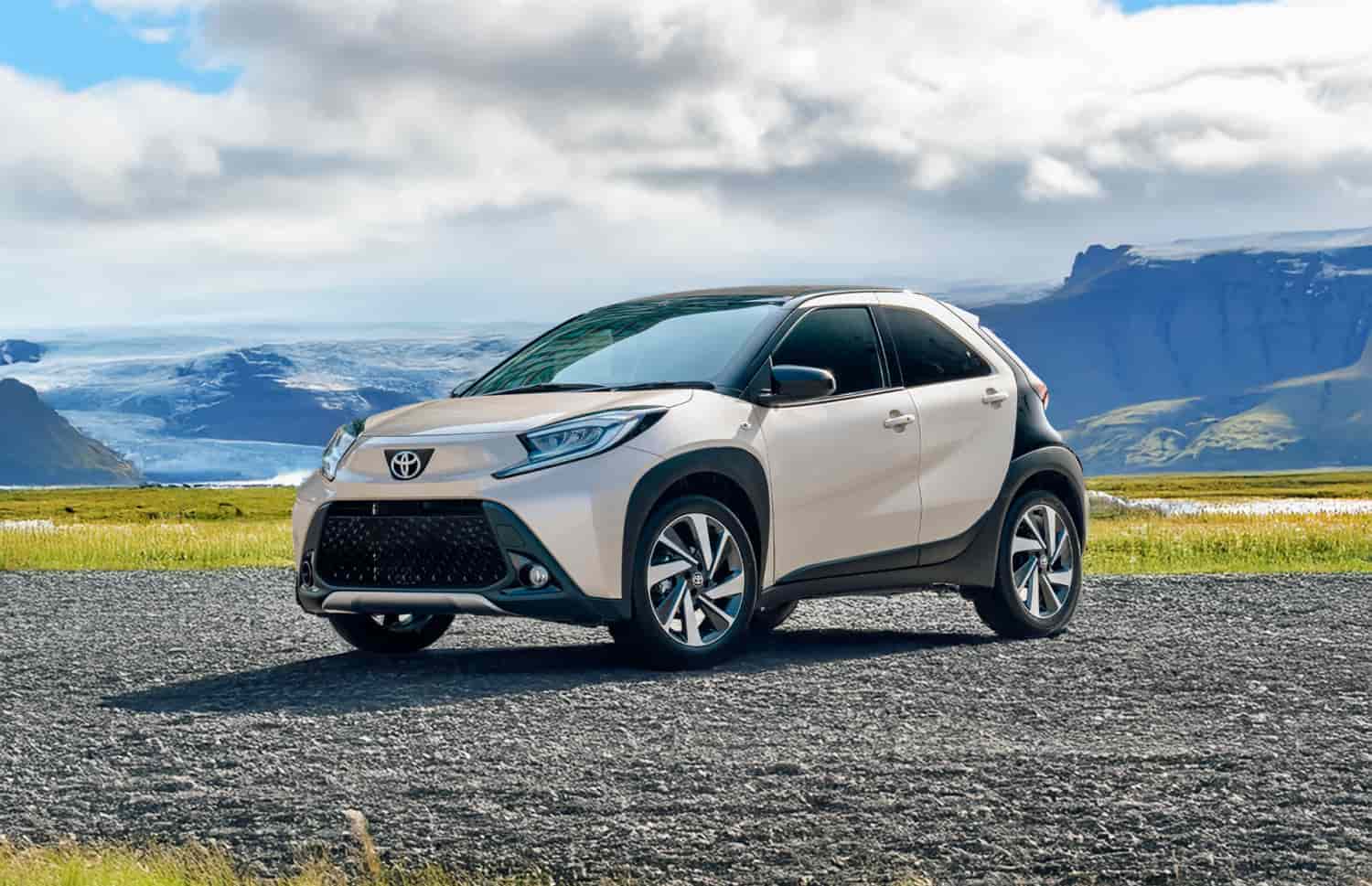 Toyota Aygo orange vif avec boîte automatique, idéale pour 4 passagers, compacte et efficace pour les déplacements en ville en Islande.