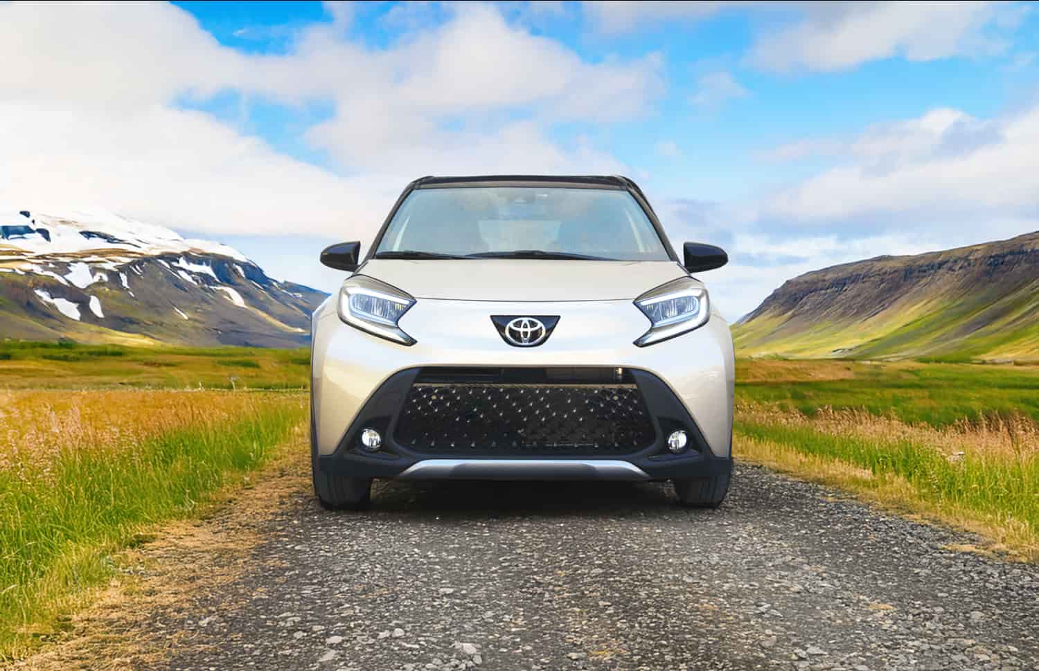 Toyota Aygo orange vif avec boîte automatique, idéale pour 4 passagers, compacte et efficace pour les déplacements en ville en Islande.
