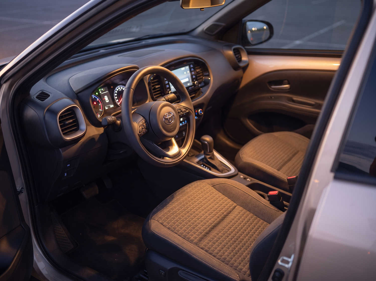 Toyota Aygo orange vif avec boîte automatique, idéale pour 4 passagers, compacte et efficace pour les déplacements en ville en Islande.
