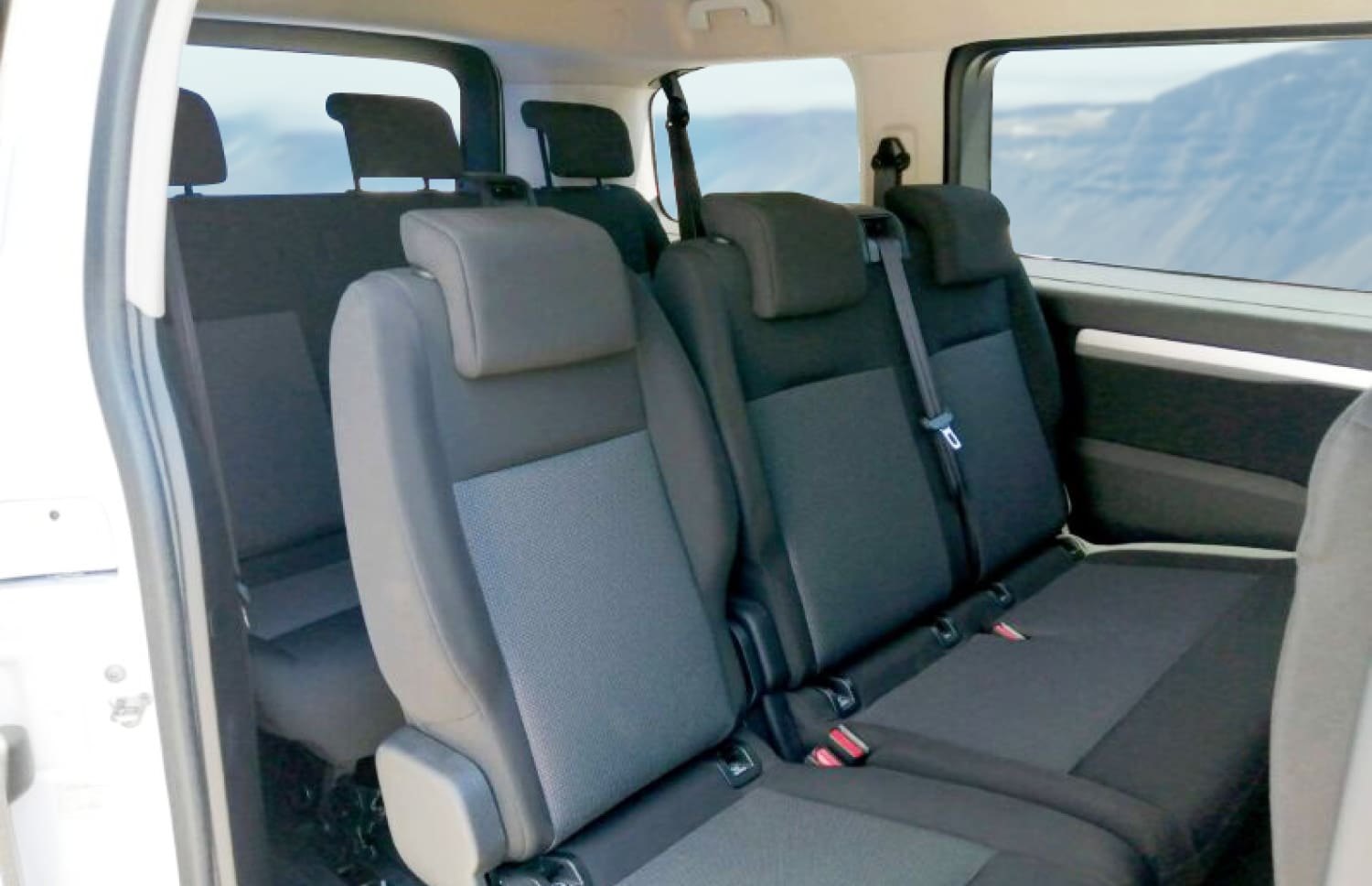 Toyota Proace argentée, van 9 places avec boîte automatique, GPS, Bluetooth, sièges chauffants et chargeur USB pour les voyages en groupe en Islande.