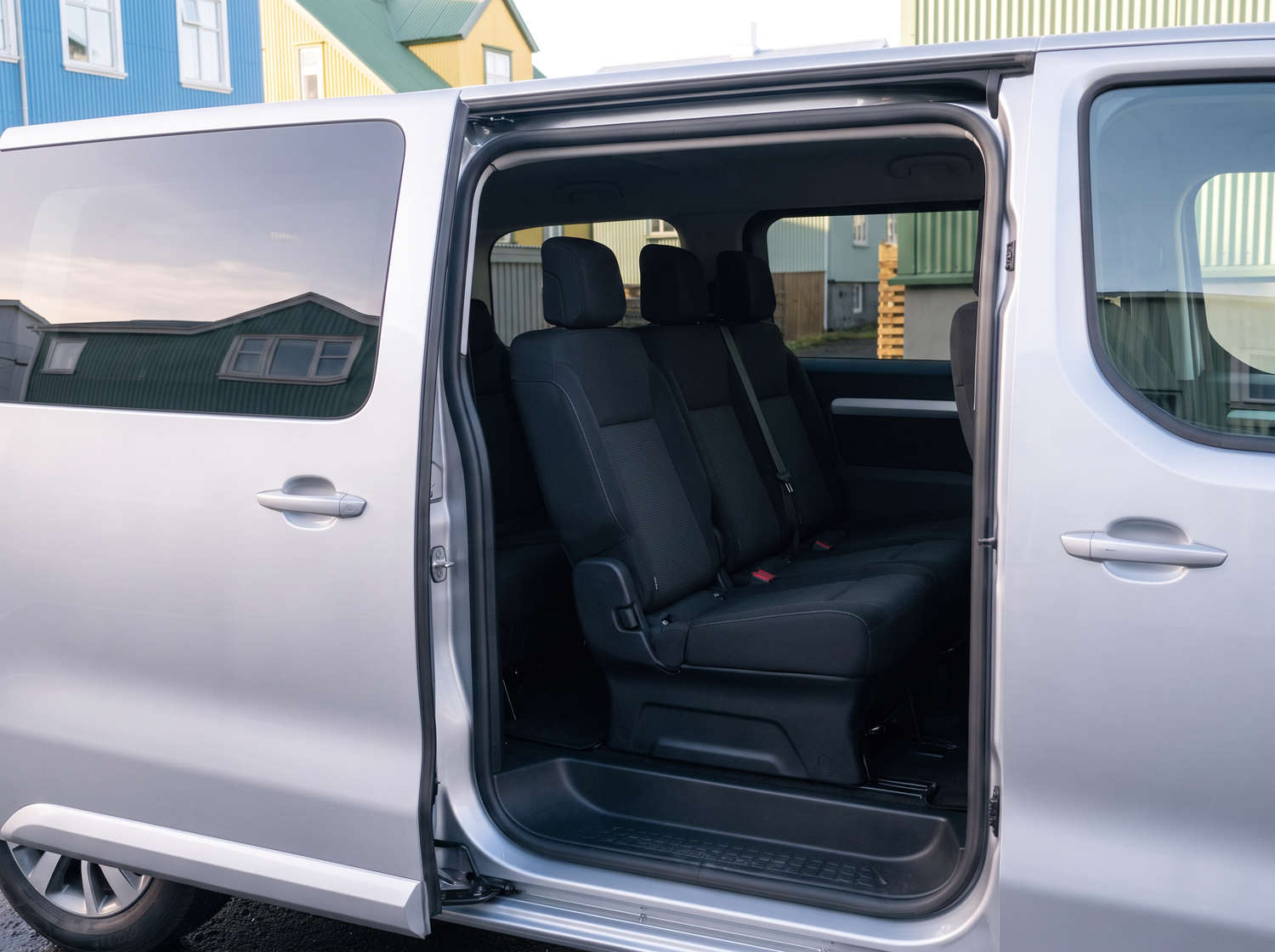 Toyota Proace argentée, van 9 places avec boîte automatique, GPS, Bluetooth, sièges chauffants et chargeur USB pour les voyages en groupe en Islande.