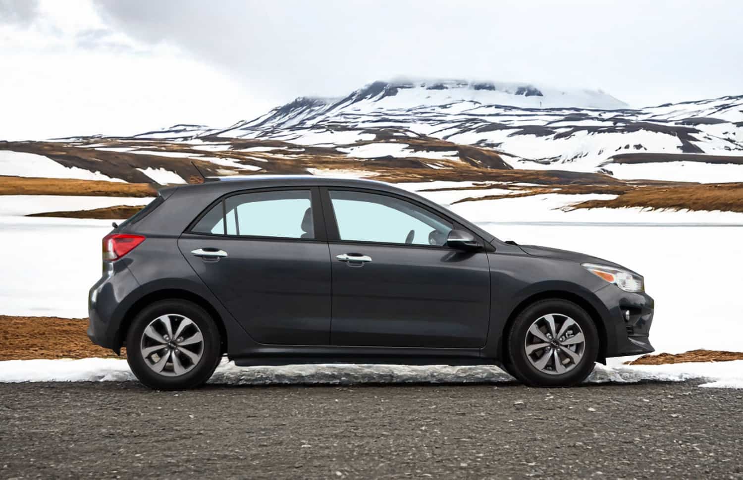 Kia Rio bleue avec boîte manuelle, GPS, caméra de recul et espace pour 5 passagers et 2 bagages, parfaite pour les road trips en Islande.