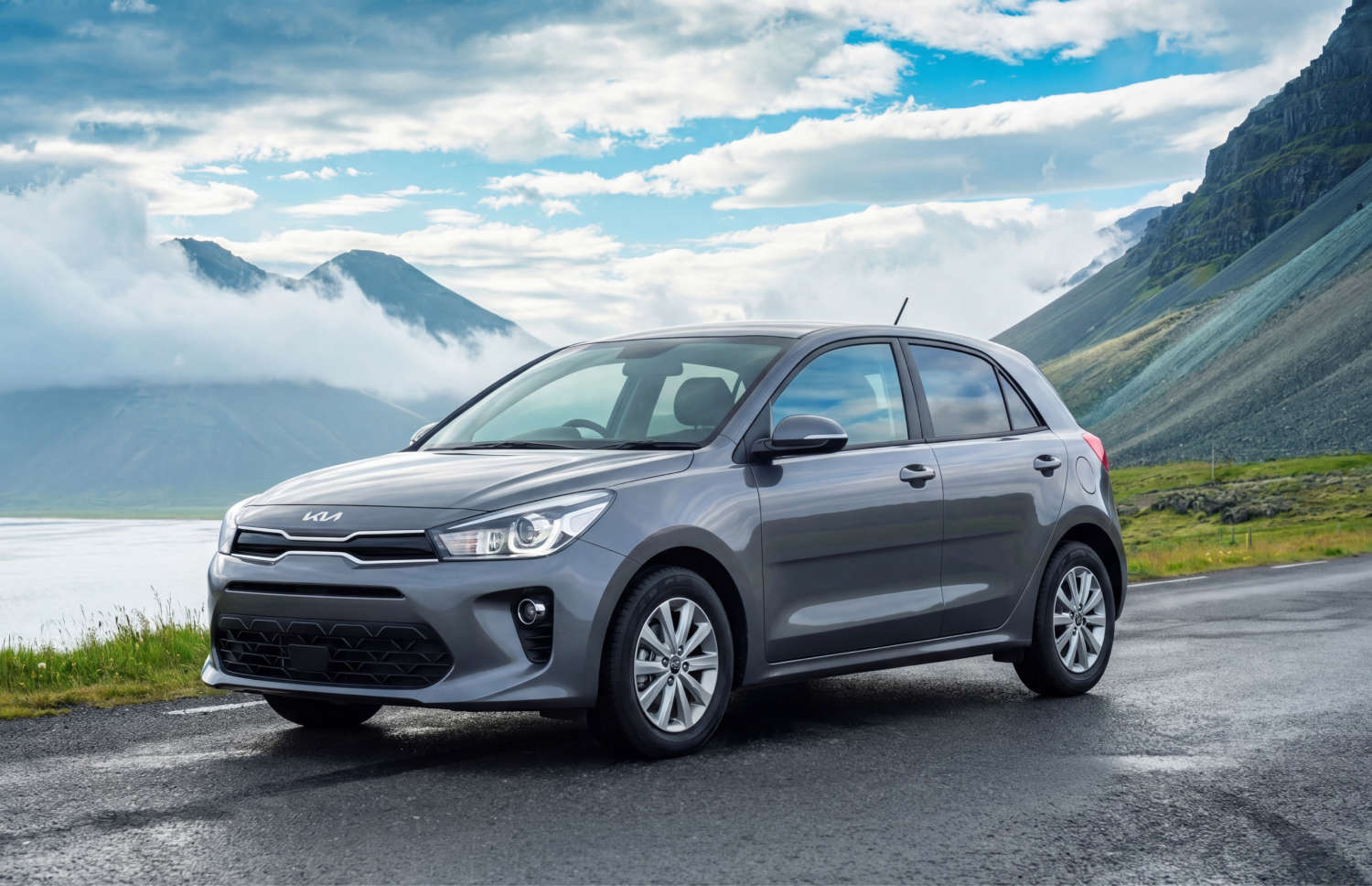 Kia Rio bleue avec boîte manuelle, GPS, caméra de recul et espace pour 5 passagers et 2 bagages, parfaite pour les road trips en Islande.
