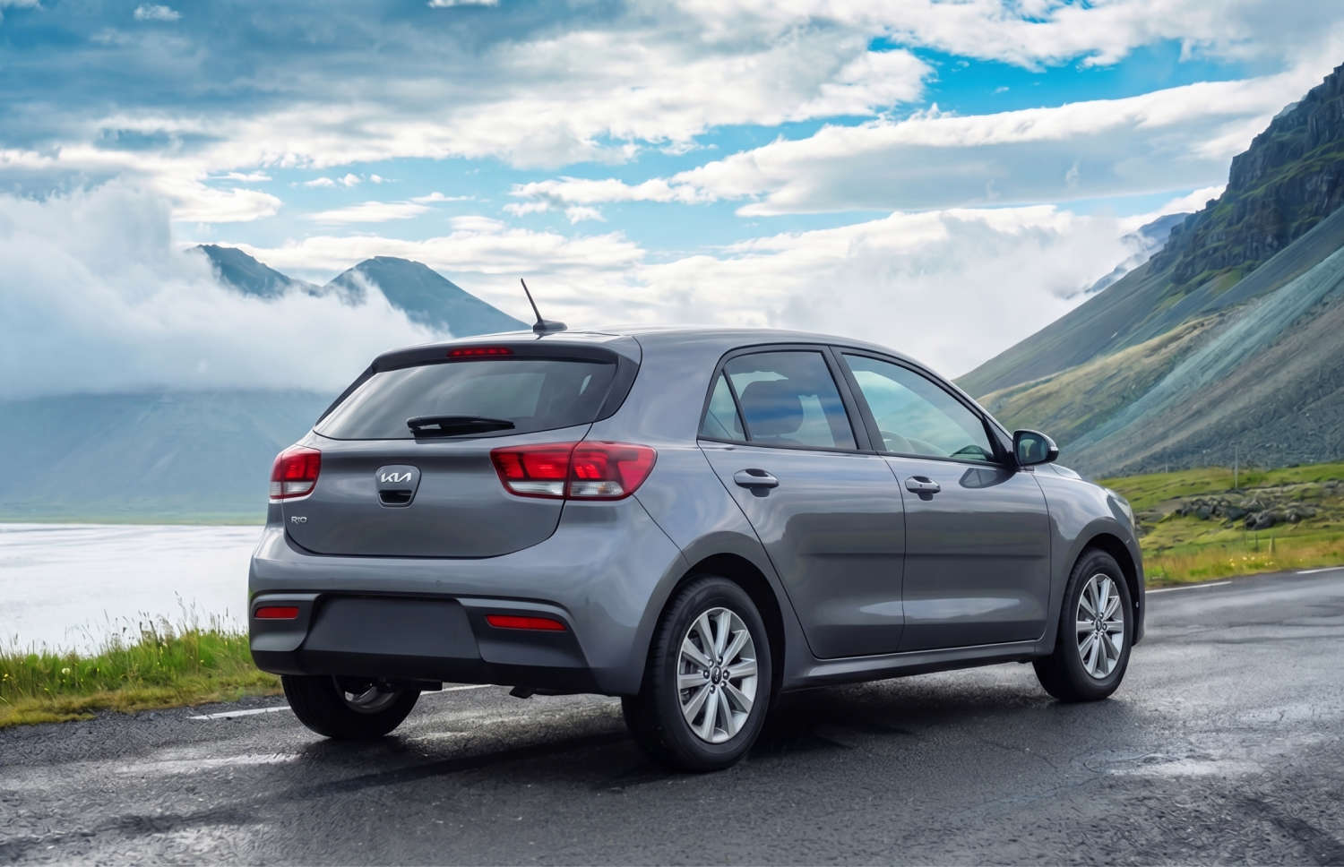 Kia Rio bleue avec boîte manuelle, GPS, caméra de recul et espace pour 5 passagers et 2 bagages, parfaite pour les road trips en Islande.