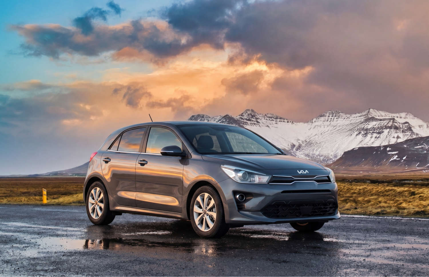 Kia Rio bleue avec boîte manuelle, GPS, caméra de recul et espace pour 5 passagers et 2 bagages, parfaite pour les road trips en Islande.