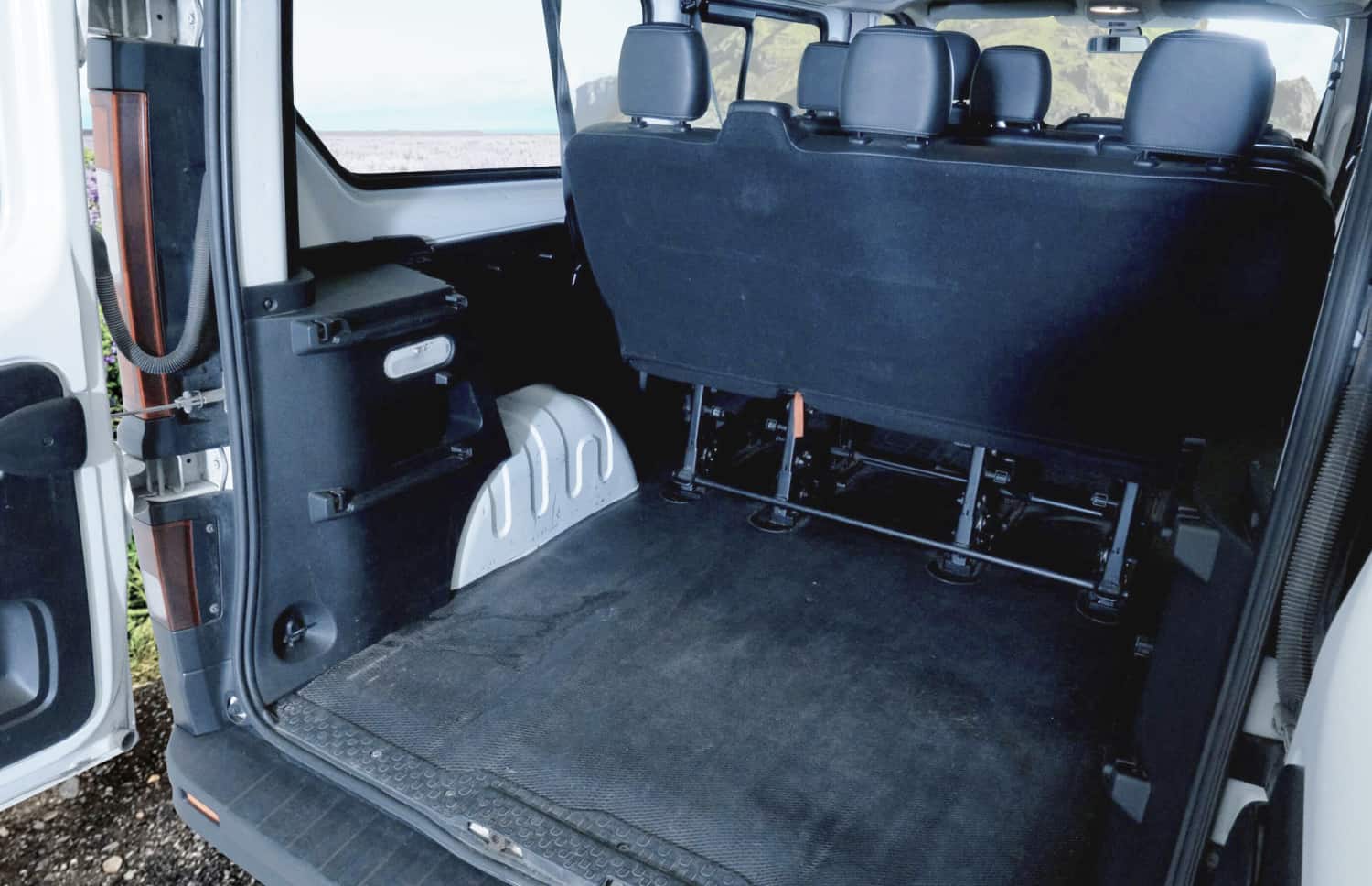 Renault Trafic rouge, van 9 places avec boîte manuelle, sièges chauffants, Bluetooth et chargeur USB, parfait pour les déplacements en groupe en Islande.