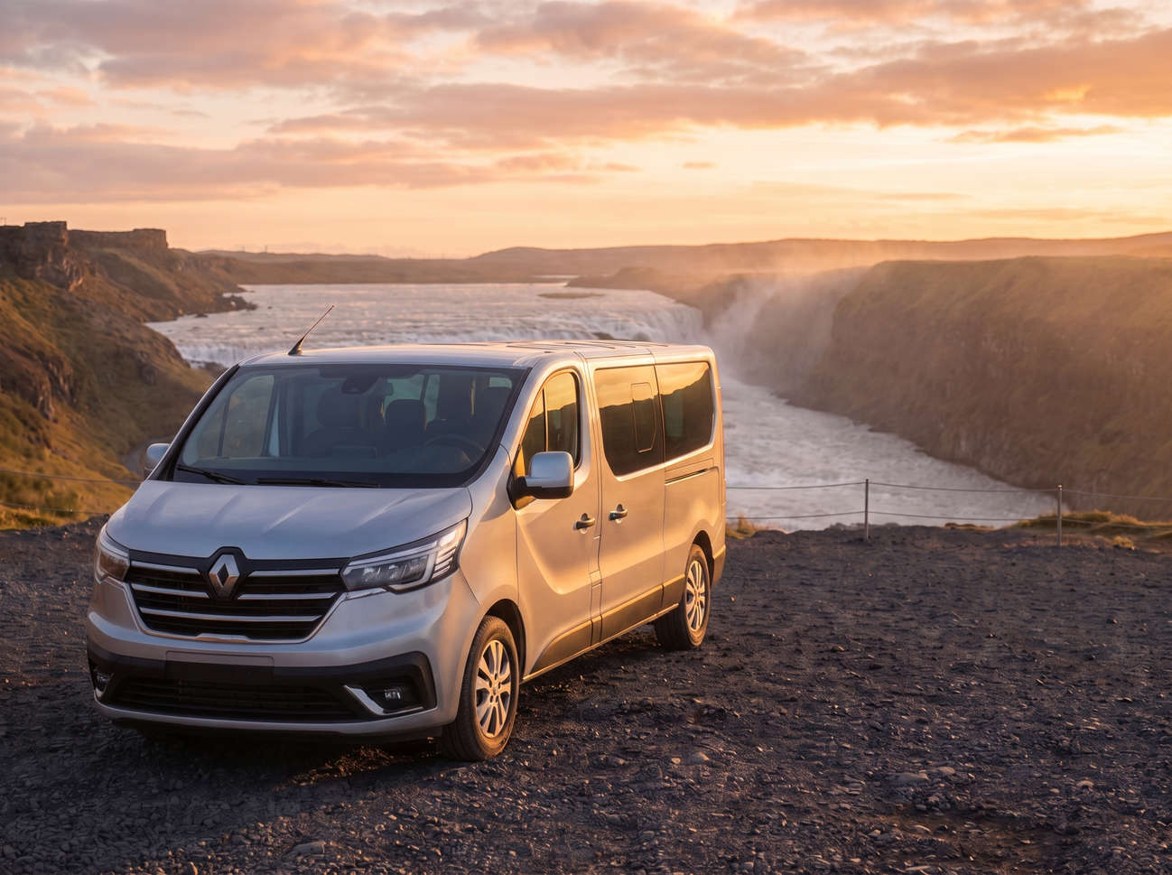 Renault Trafic rouge, van 9 places avec boîte manuelle, sièges chauffants, Bluetooth et chargeur USB, parfait pour les déplacements en groupe en Islande.