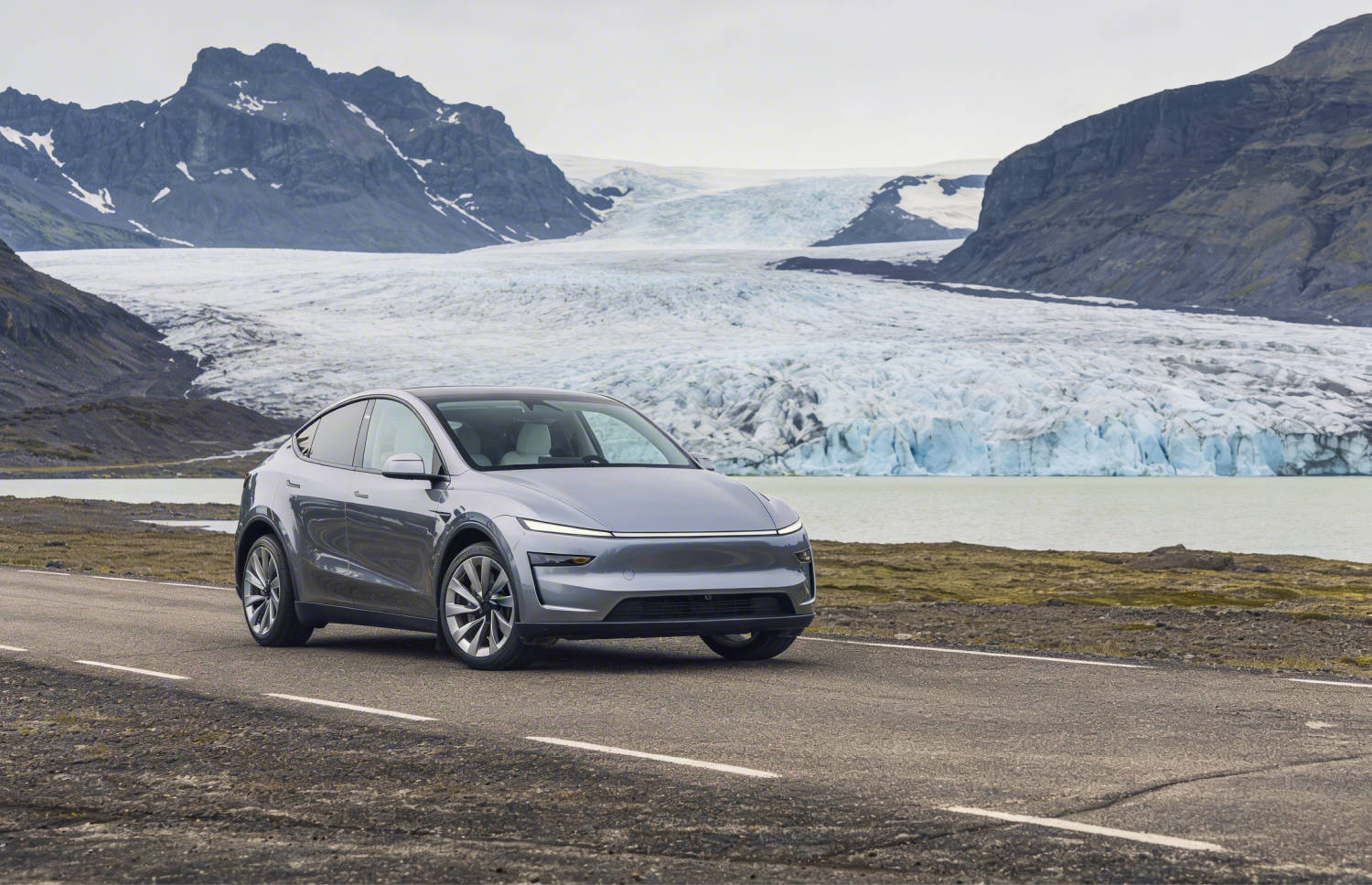 Tesla Model Y bleu, SUV électrique avec boîte automatique, GPS, caméra de recul, sièges chauffants et espace pour 5 passagers et 2 bagages en Islande.