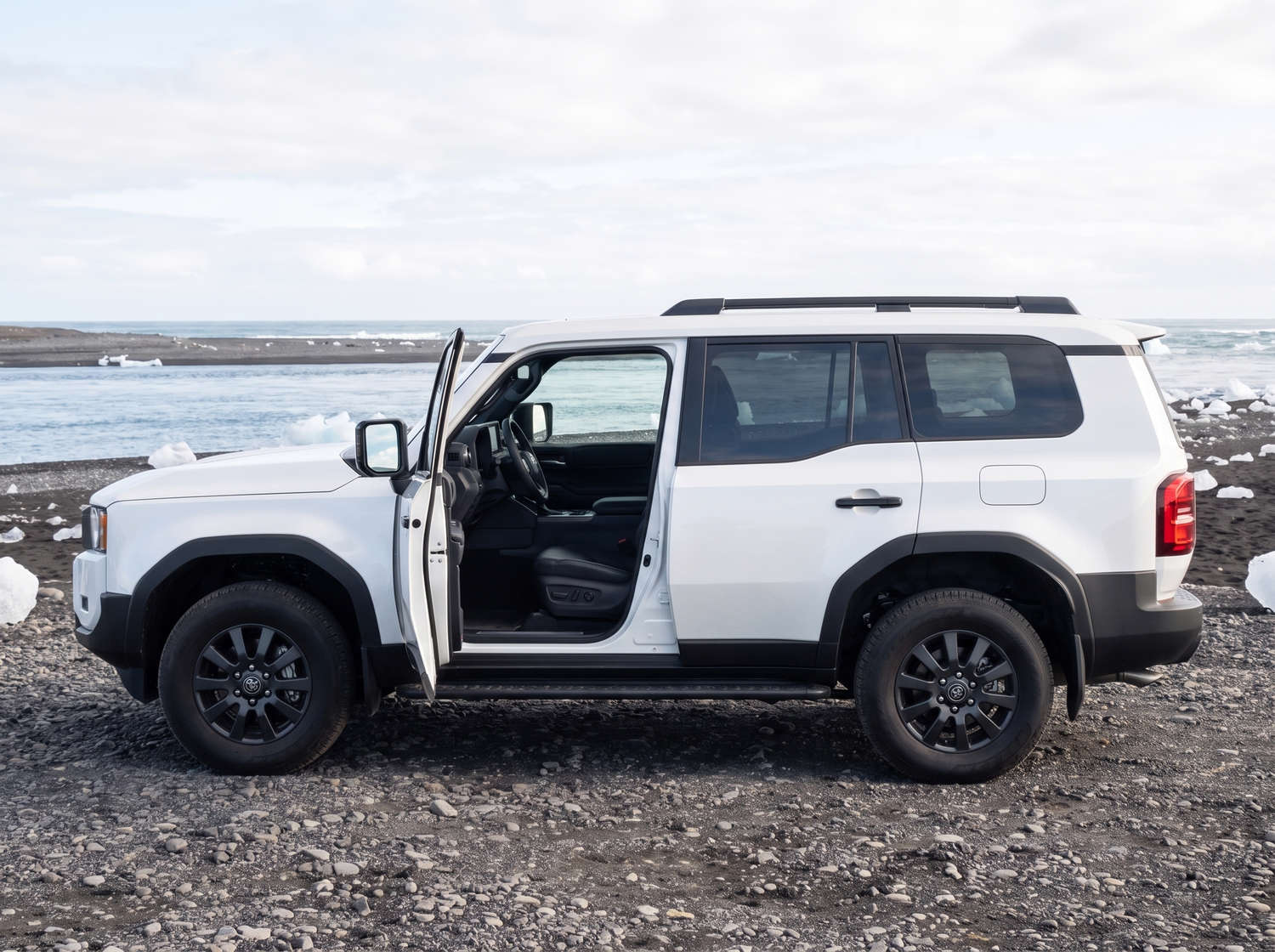 Toyota Land Cruiser 250 blanc, SUV 4x4 avec boîte automatique, 7 places, chargeur USB, Bluetooth et sièges chauffants, idéal pour les aventures tout-terrain en Islande.