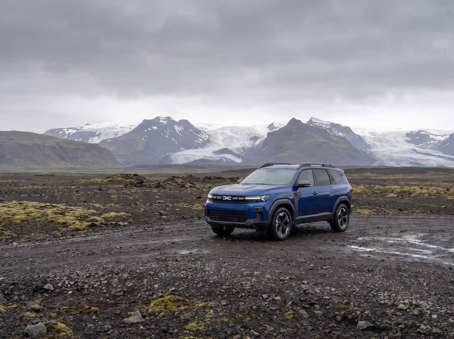 Dacia Bigster bleu avec boîte manuelle et transmission intégrale, 5 places et capacité pour 4 bagages, conçu pour les routes accidentées d’Islande avec confort.
