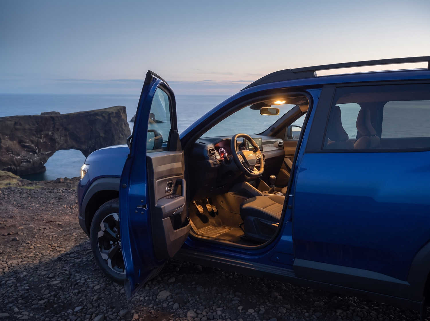 Dacia Bigster bleu avec boîte manuelle et transmission intégrale, 5 places et capacité pour 4 bagages, conçu pour les routes accidentées d’Islande avec confort.
