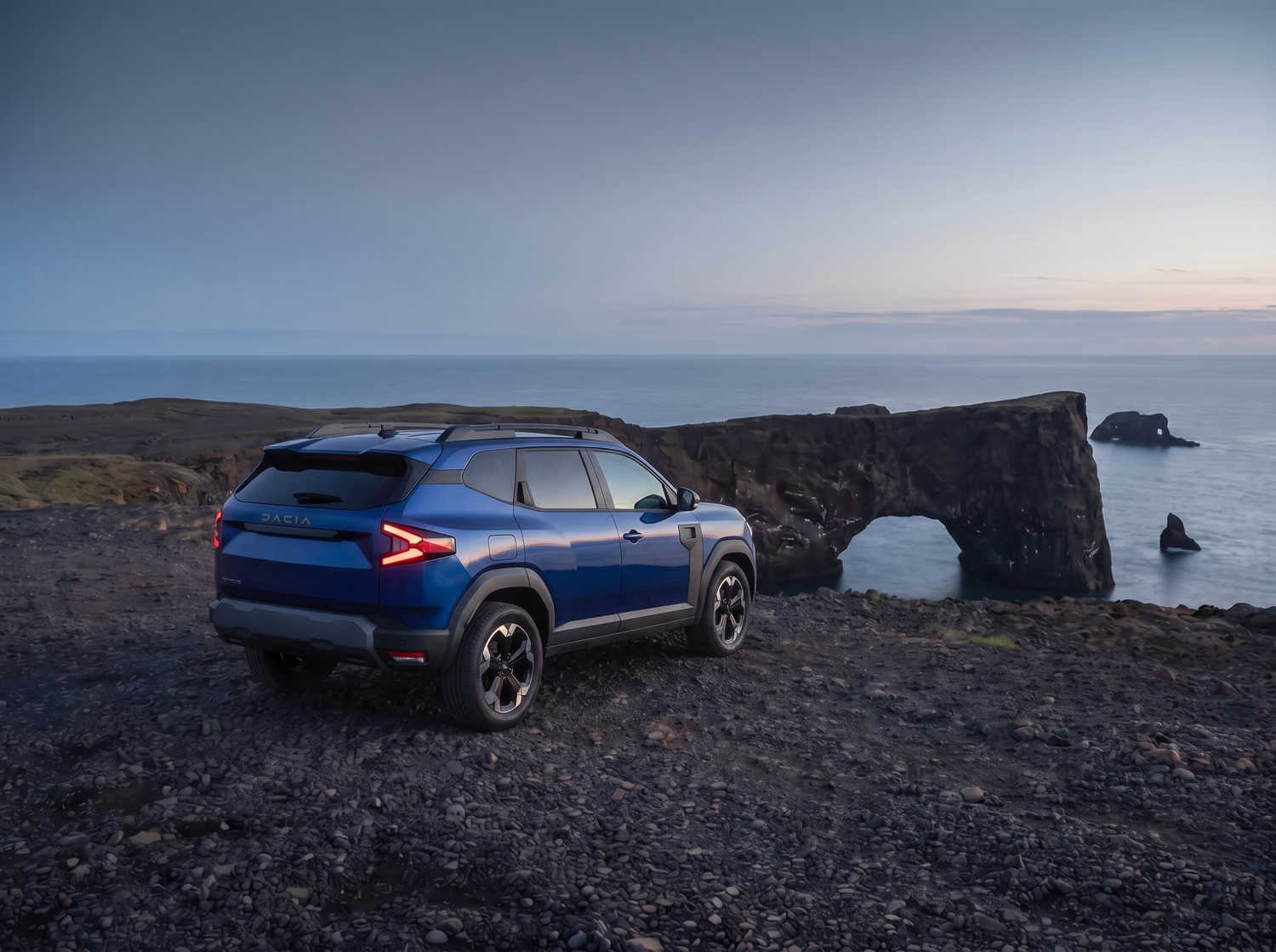 Dacia Bigster bleu avec boîte manuelle et transmission intégrale, 5 places et capacité pour 4 bagages, conçu pour les routes accidentées d’Islande avec confort.