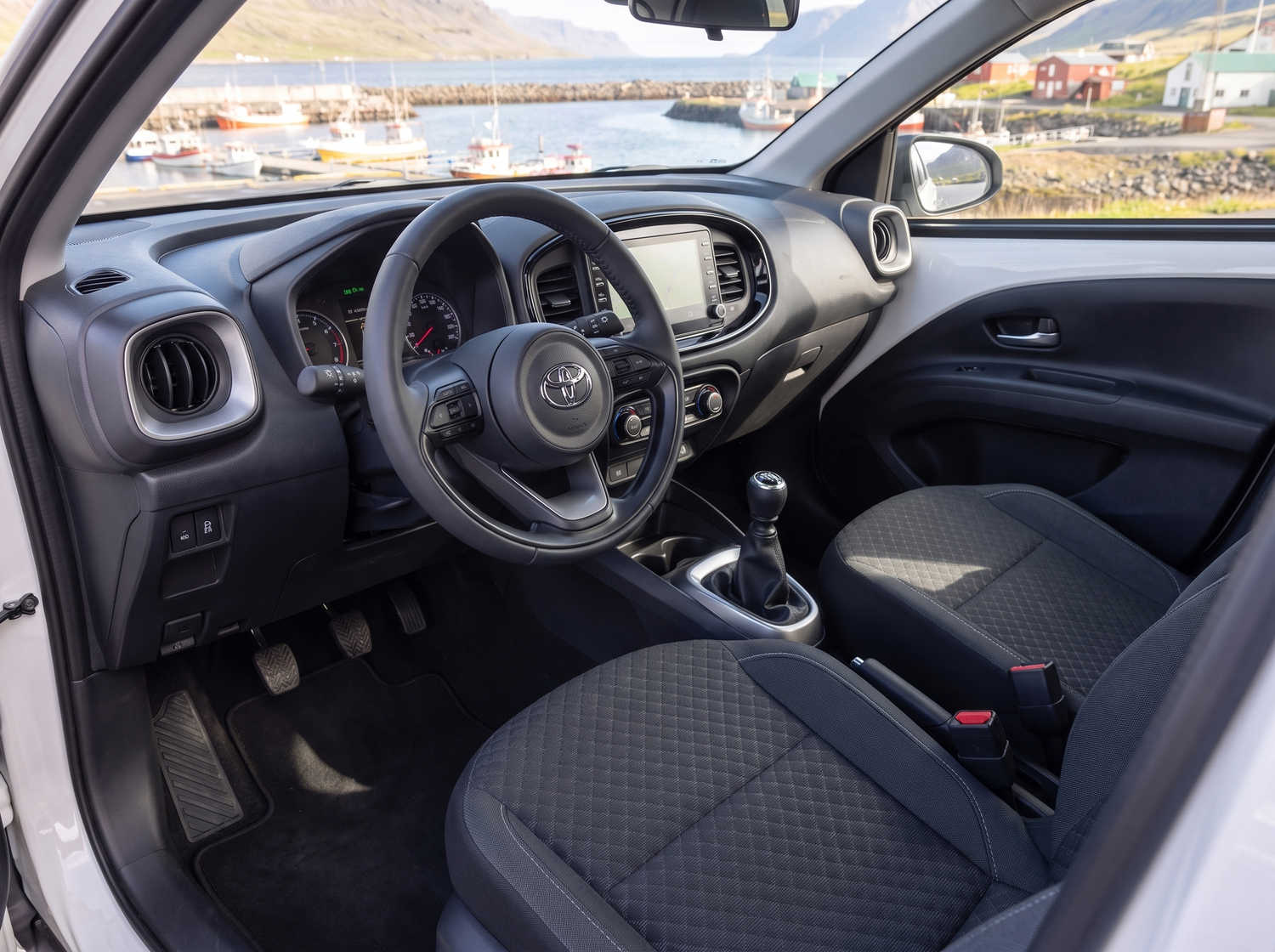 Toyota Aygo compacte gris métallisé avec boîte manuelle, parfaite pour 4 passagers, idéale pour la conduite en ville en Islande.