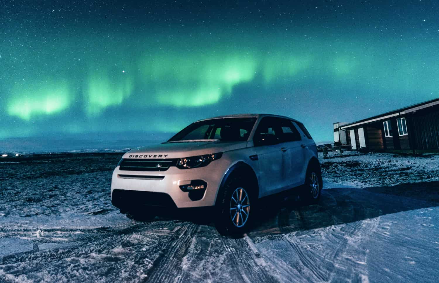 Land Rover Discovery Sport blanc, SUV 4x4 avec boîte automatique, GPS, caméra de recul et sièges chauffants, idéal pour 5 passagers en Islande.